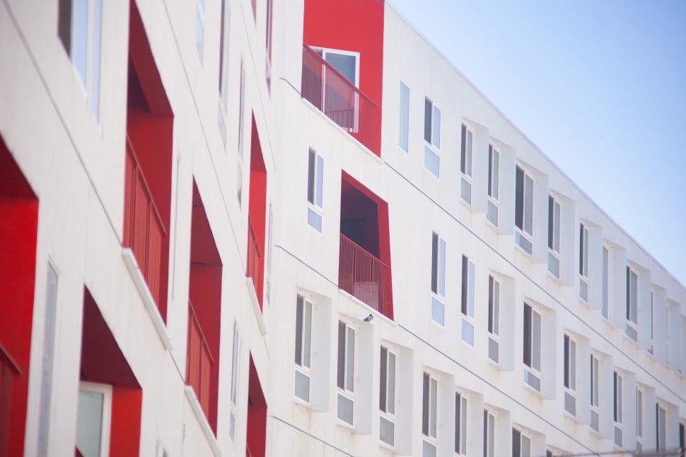 Free Image of Modern red and white apartment building with many windows. 