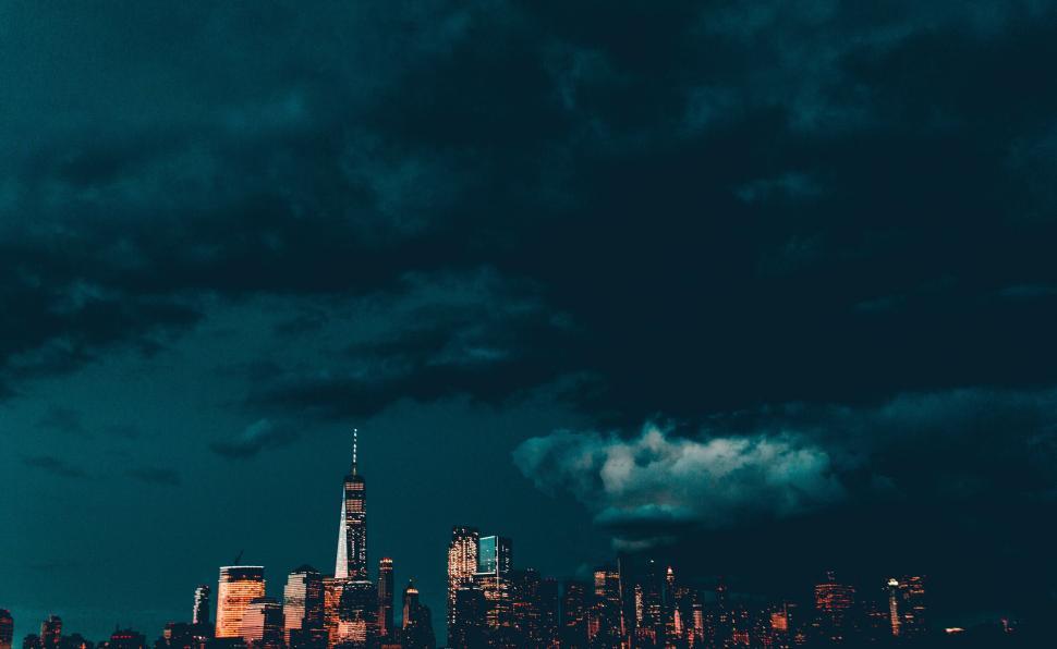 Free Image of City skyline of tall buildings under dark evening sky. 