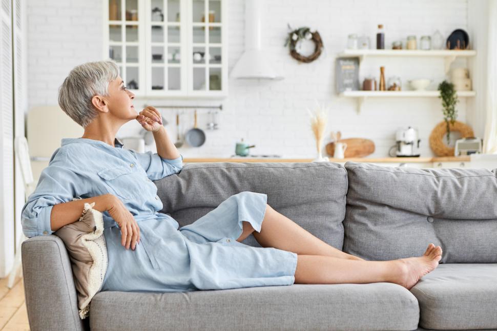 Free Image of Mature Adult Woman lounges on the couch 