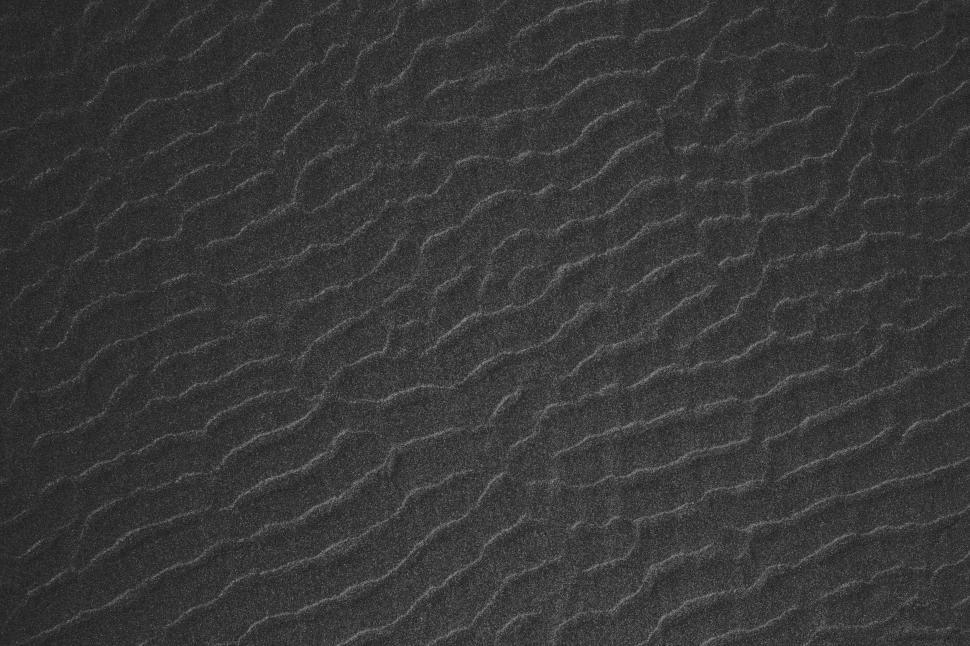 Free Image of Close-up texture of dark sand with wavy patterns 