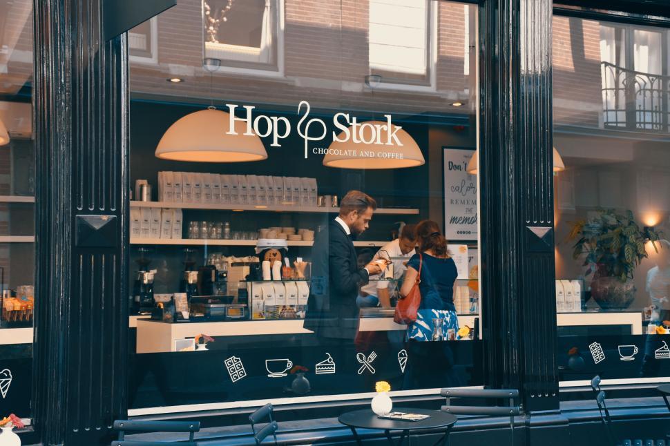 Free Image of Two people inside a modern cafe conversing over coffee 