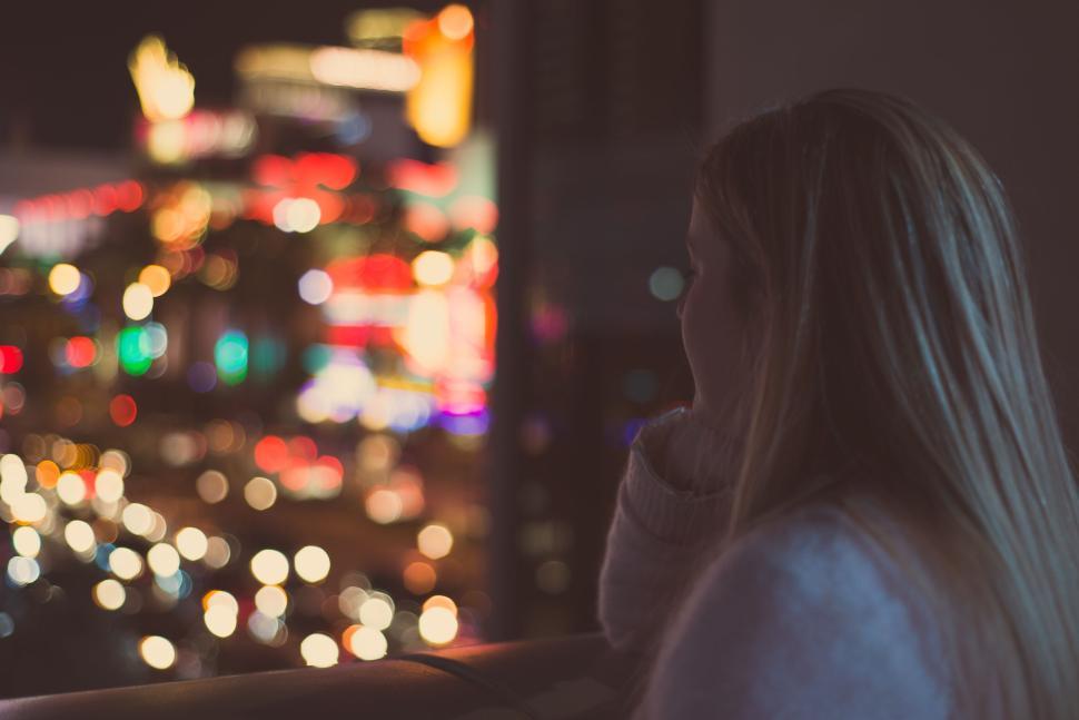 Free Image of Person gazing into distance over a city night skyline 