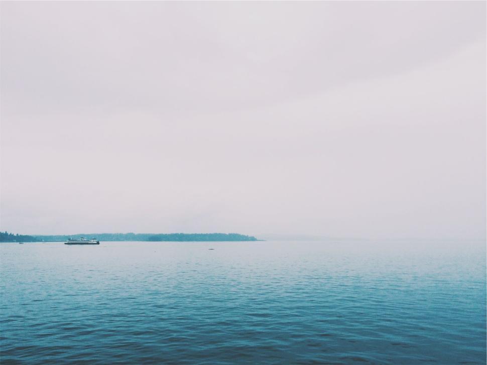 Free Image of Expansive view of a calm ocean on a cloudy day 