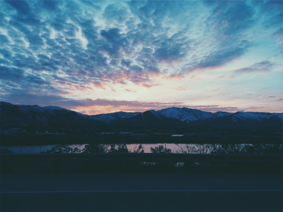 Free Image of Stunning dusk sky over mountain landscape by a lake 