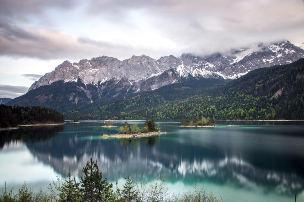 Free Image of Mountain range reflection on a serene lake surface 