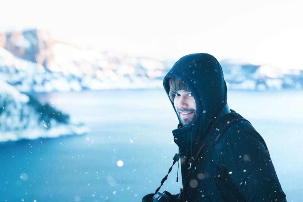 Free Image of Man in winter jacket with camera in snowy landscape 