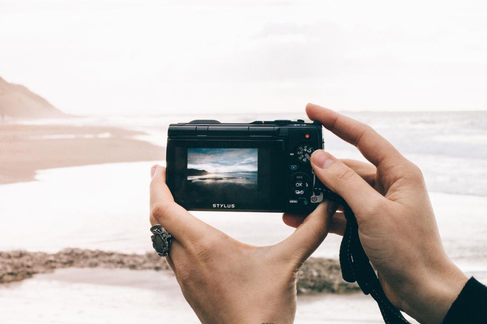 Free Image of Person capturing serene beach view with camera 
