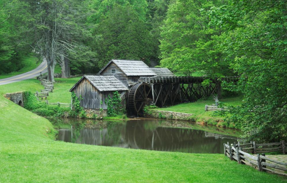 Free Image of Rustic watermill and pond with lush green surroundings 