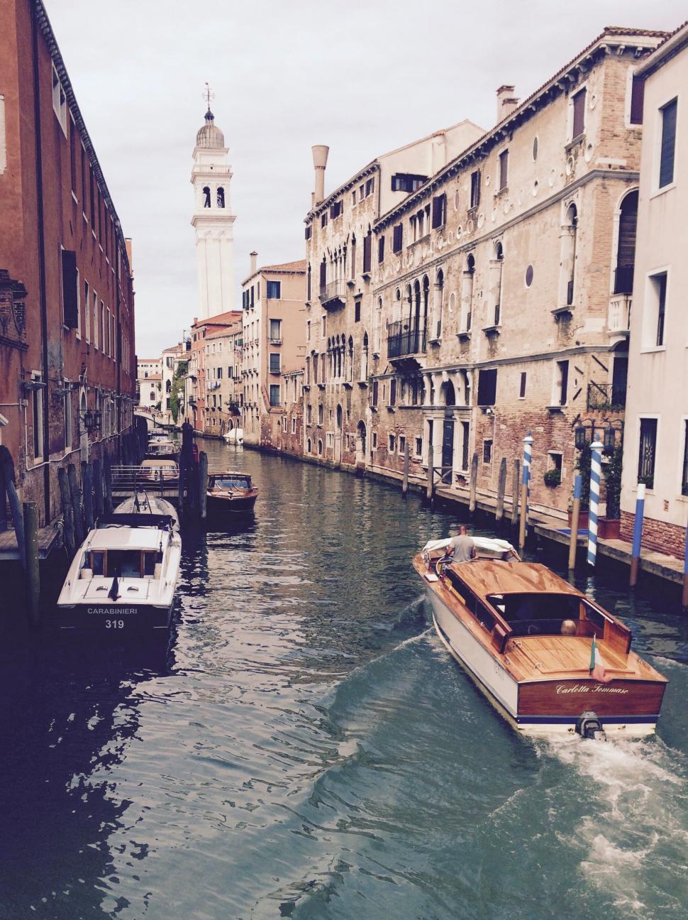 Free Image of Venetian canal with boats floating beside old buildings 