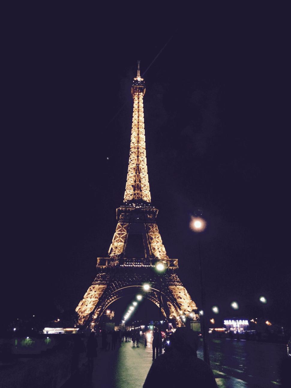 Free Image of The Eiffel Tower illuminated against a dark sky. 