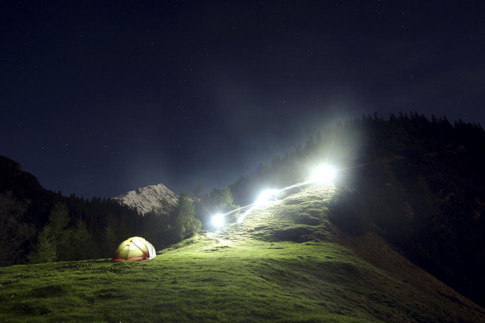Free Image of Illuminated mountains with bright lights and a tent. 
