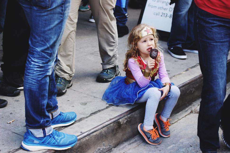 Free Image of Little girl in Wonder Woman costume eating ice cream 