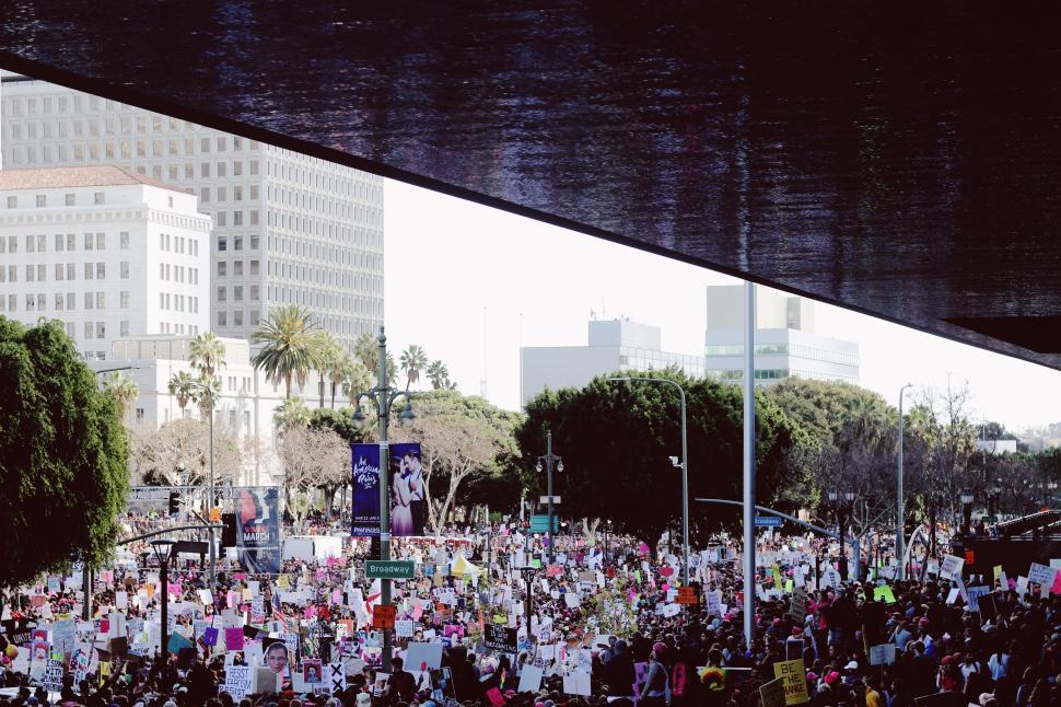Free Image of Large crowd with protest signs in a city under bridge. 