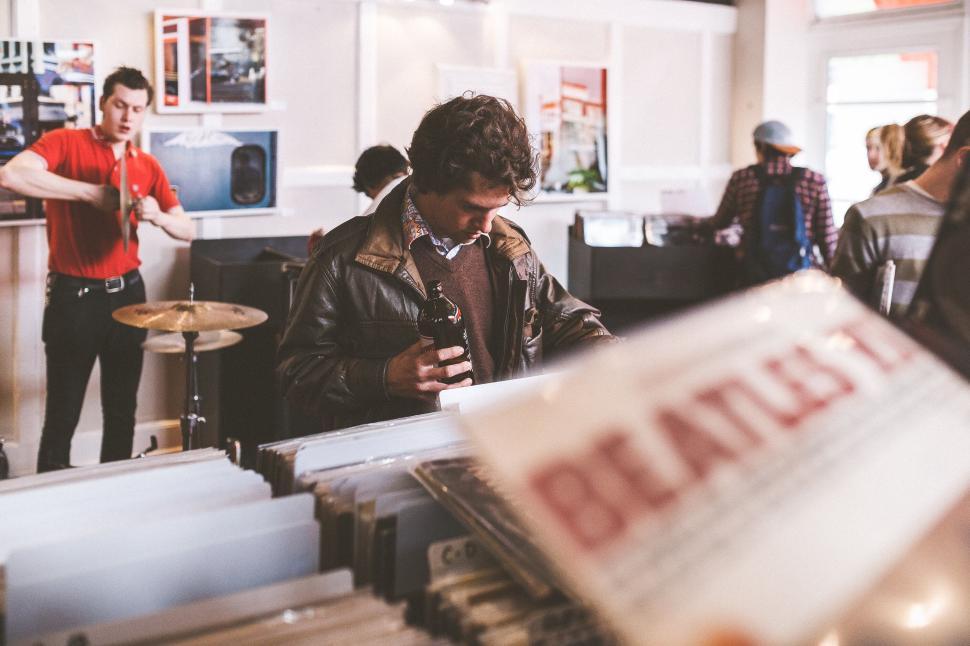 Free Image of Man browsing records in a cozy vintage record store 
