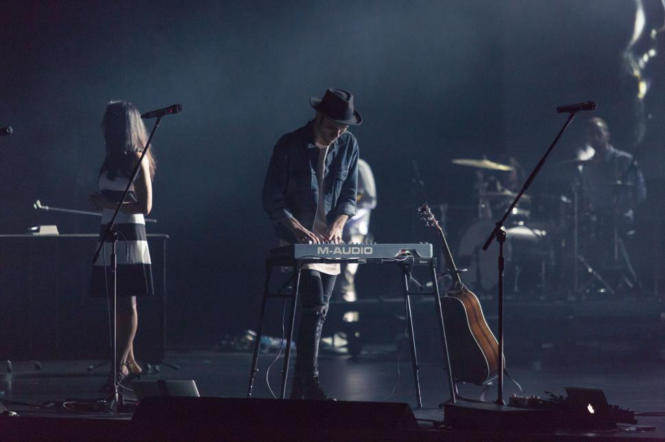 Free Image of Band performing on stage with keyboards and guitar. 