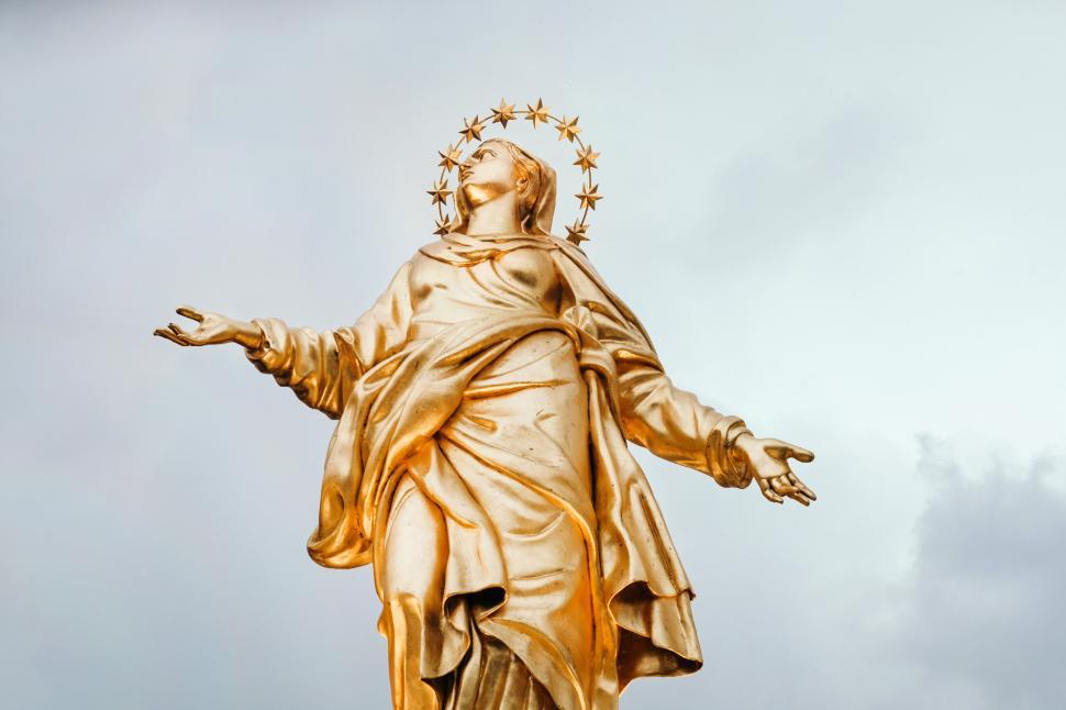 Free Image of Golden statue with star halo against a cloudy sky 