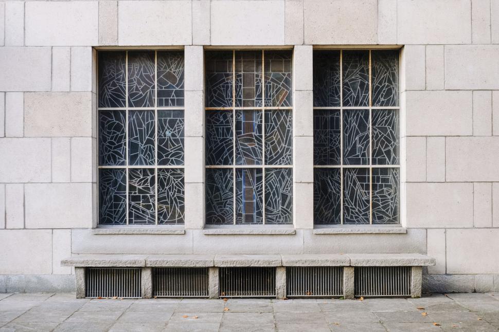 Free Image of Stained glass windows on a stone building facade 