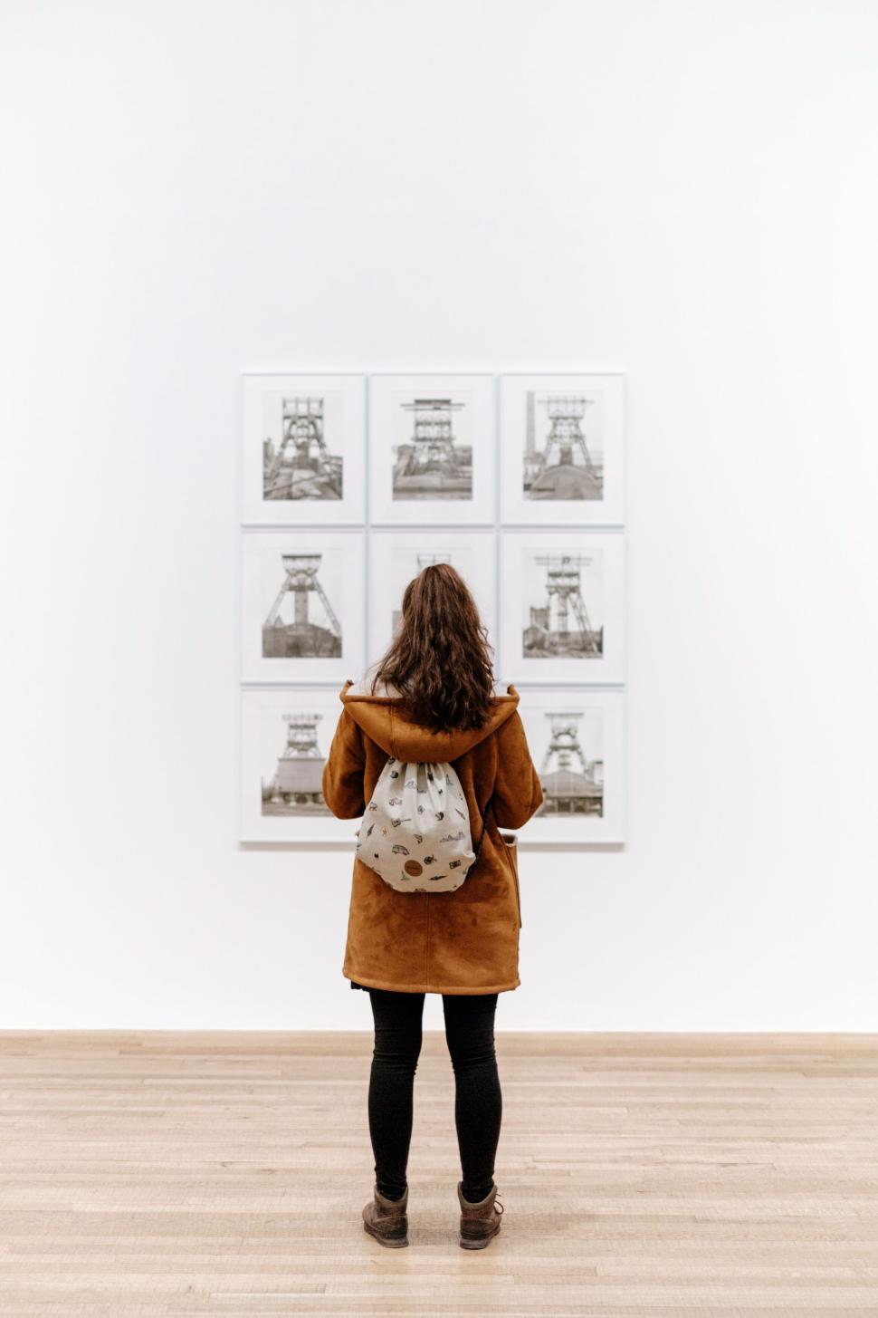 Free Image of Person with backpack viewing art in gallery setting 