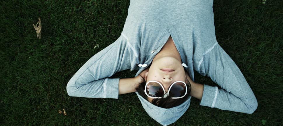 Free Image of Person lying on grass with hands behind head relaxing day 