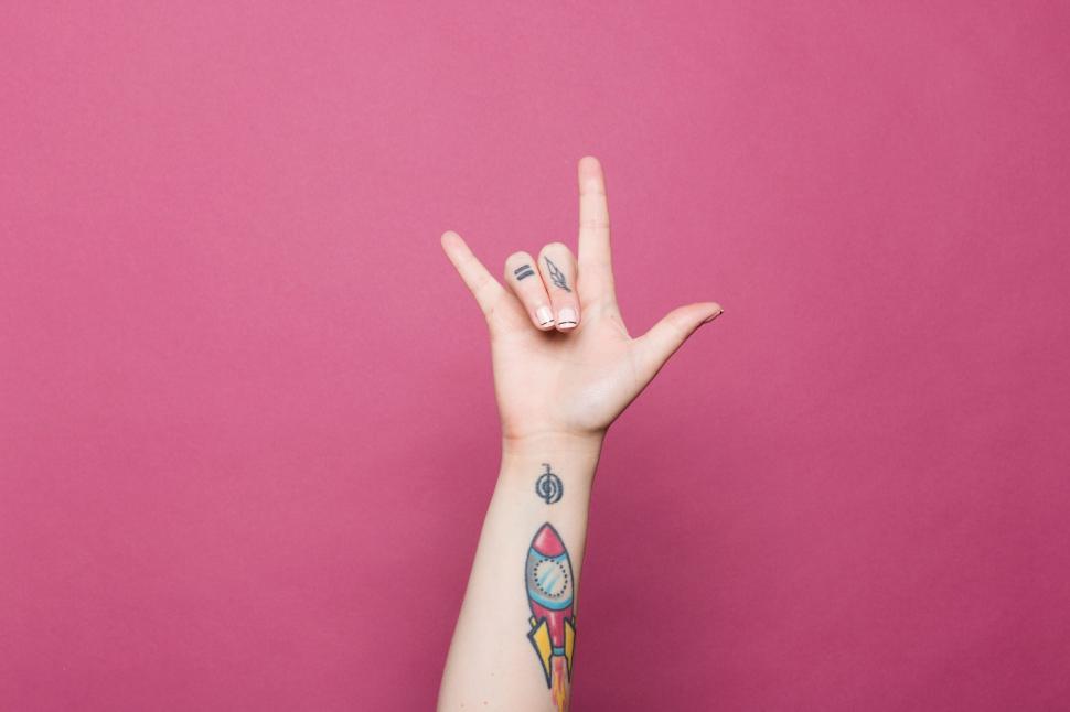 Free Image of Hand making  I love you  sign with colorful tattoos 