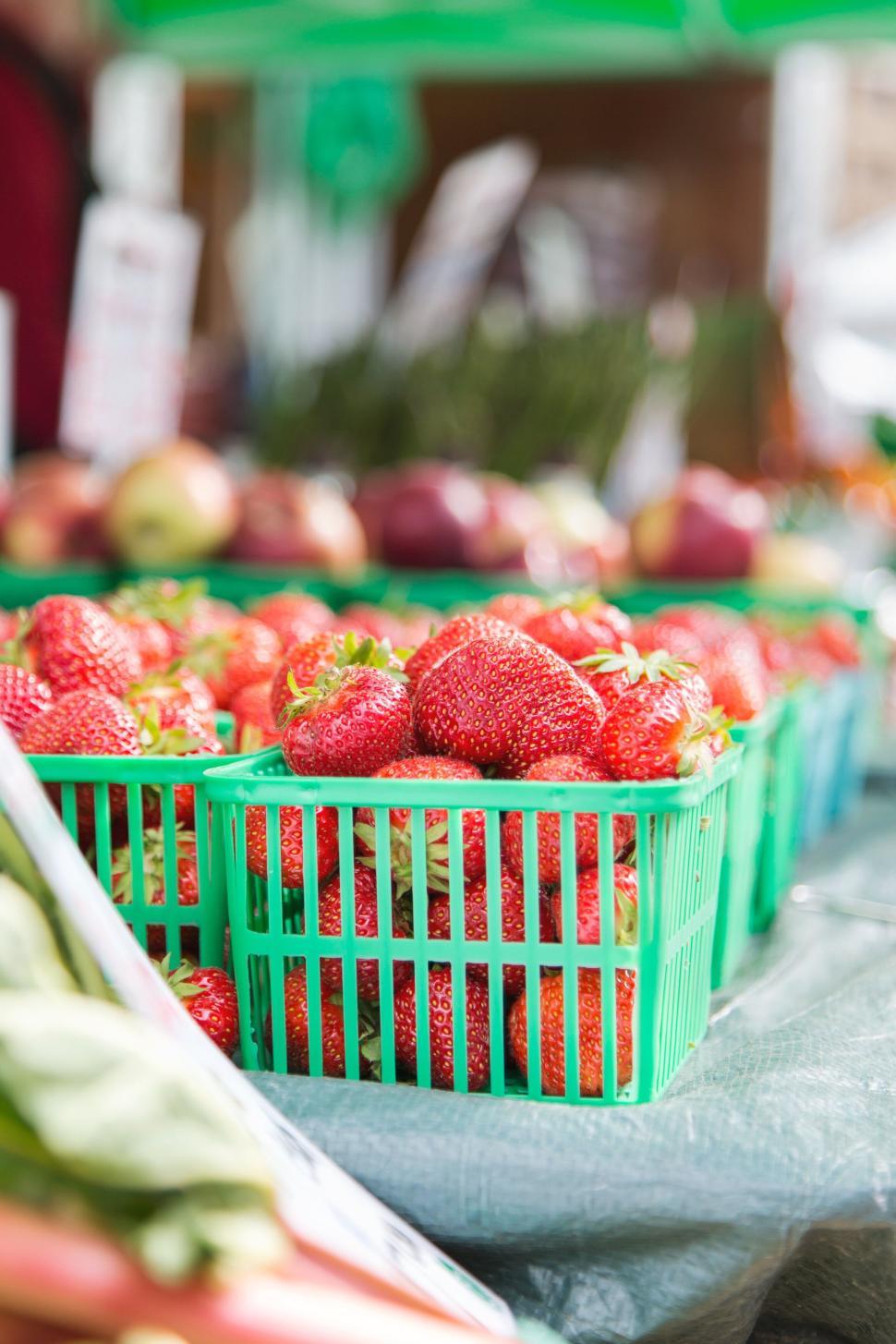 Free Image of Bright red strawberries in green baskets at a market 