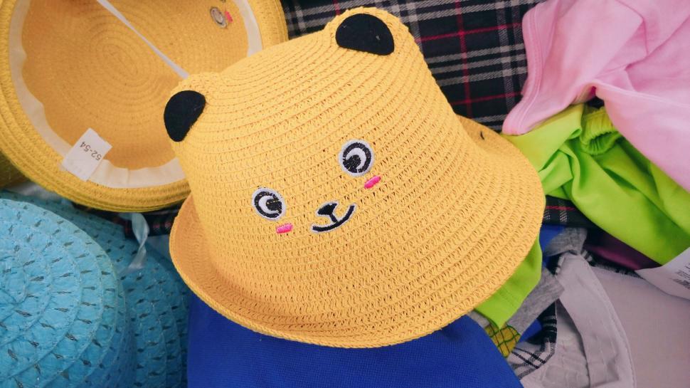 Free Image of Cute yellow hat with bear face design on display stand 