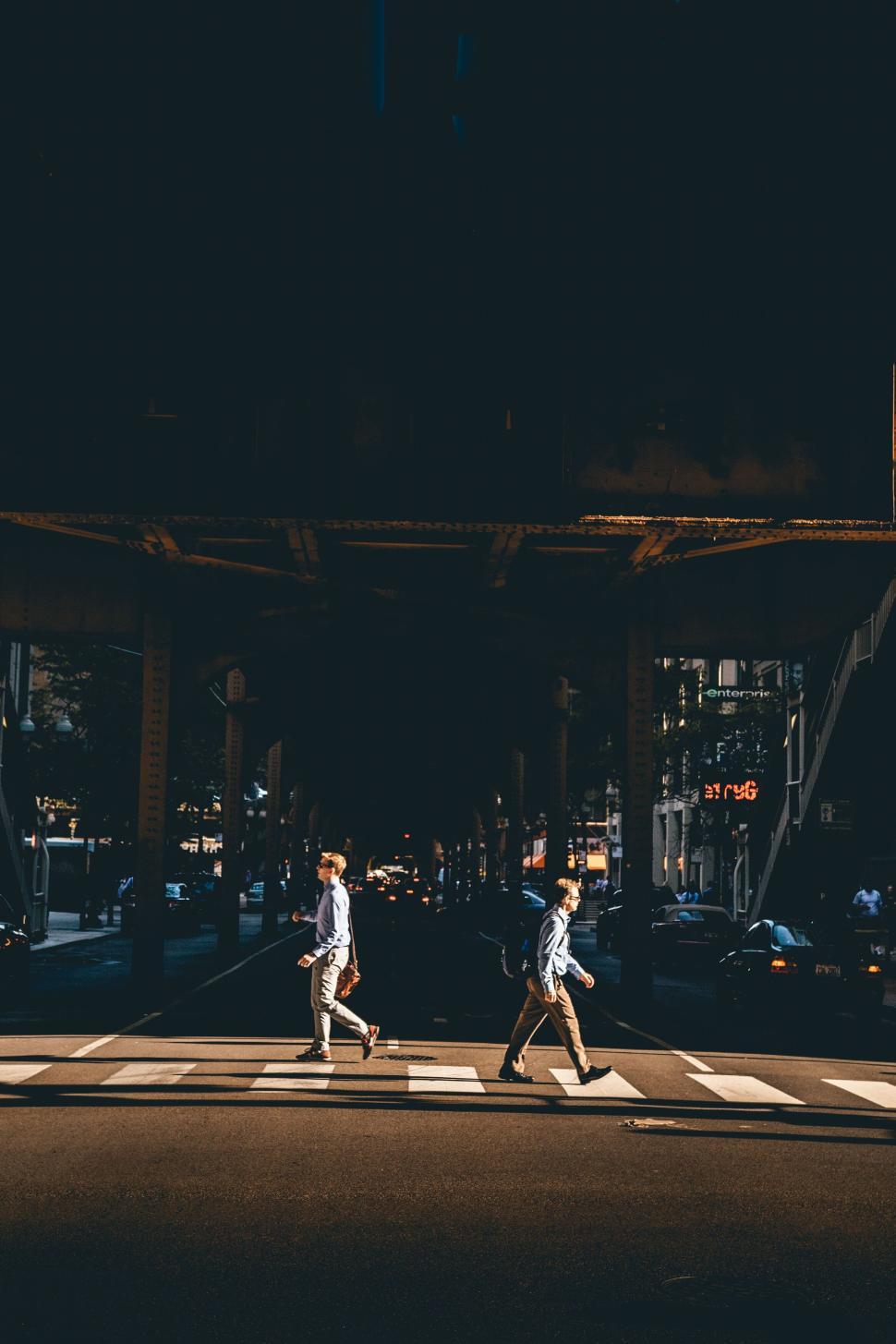 Free Image of People walking under the elevated Chicago L train tracks. 
