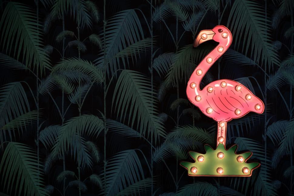 Free Image of Neon flamingo with palms wallpaper in the background. 