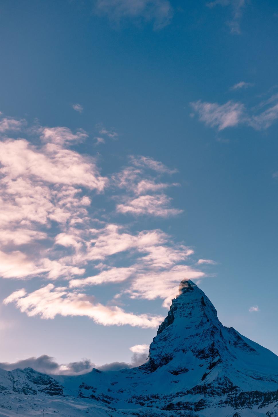 Free Image of Mountain peak with clear sky and scattered clouds 