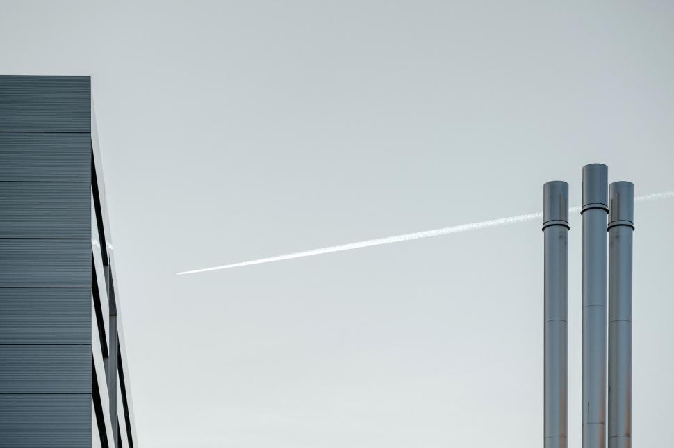 Free Image of Modern Industrial Chimneys and Building with Jet Trail 