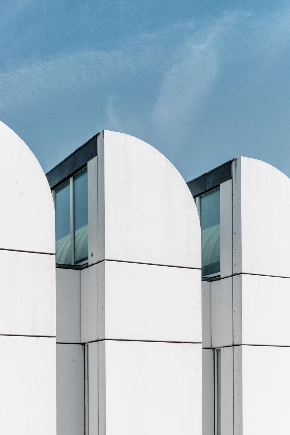 Free Image of Modern white building with curved rooftop against blue sky 