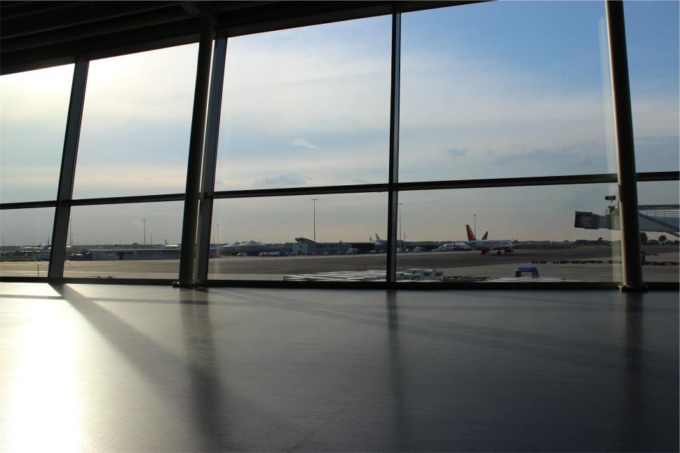 Free Image of Airplanes on tarmac viewed through terminal windows. 
