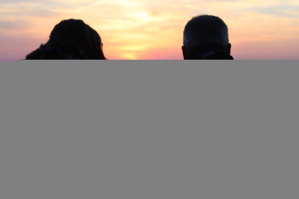 Free Image of A couple watching sunset from a high vantage point. 