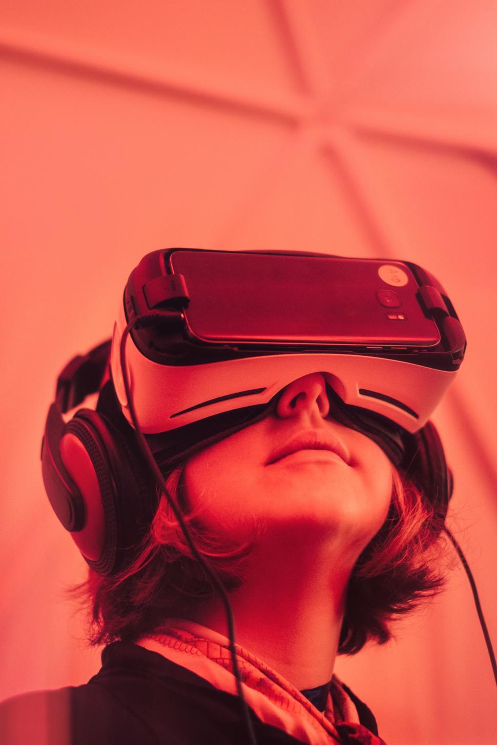 Free Image of Person wearing virtual reality headset in red-lit room 