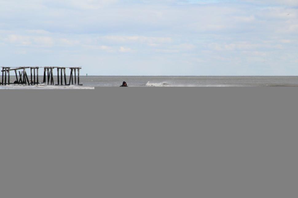 Free Image of Person with bicycle on a deserted, windswept beach. 