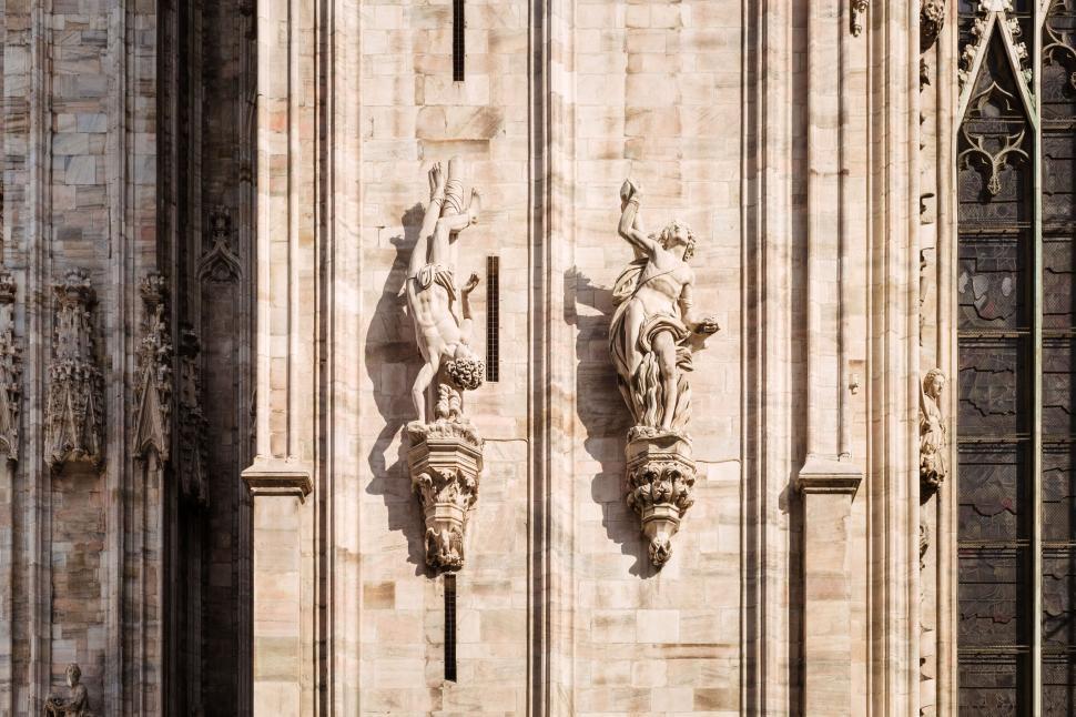 Free Image of Two intricate stone statues on a historical cathedral wall 