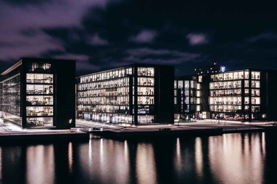 Free Image of Illuminated office buildings reflecting on calm waters 