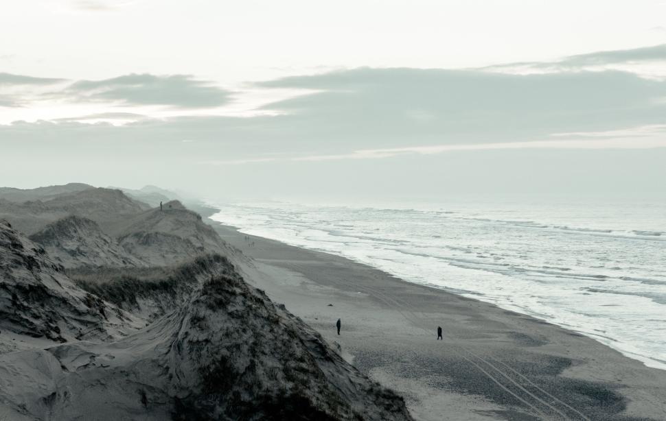 Free Image of Desolate sandy beach under a gloomy overcast sky 