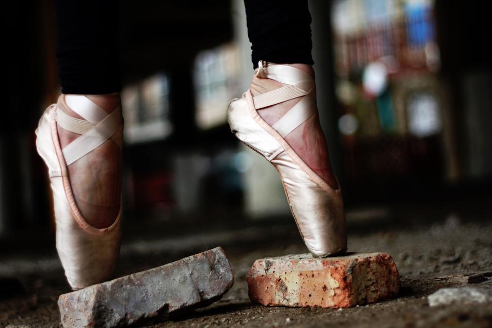 Free Image of Ballet dancer balancing on bricks in urban setting 