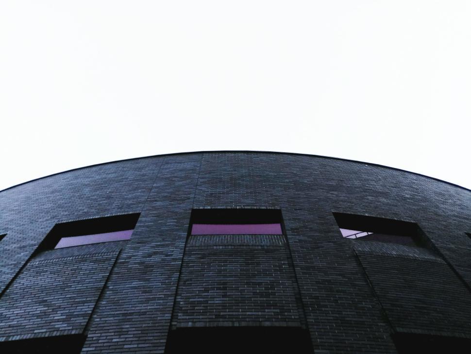 Free Image of Modern arched building with gloomy sky background view 