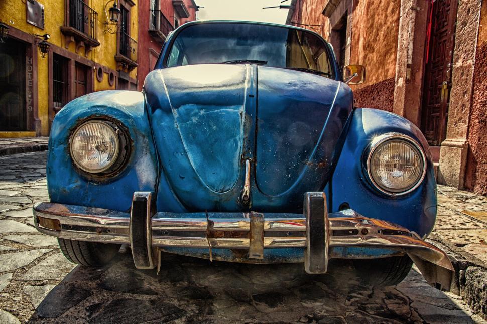 Free Image of Rustic blue car parked on colorful historic street 