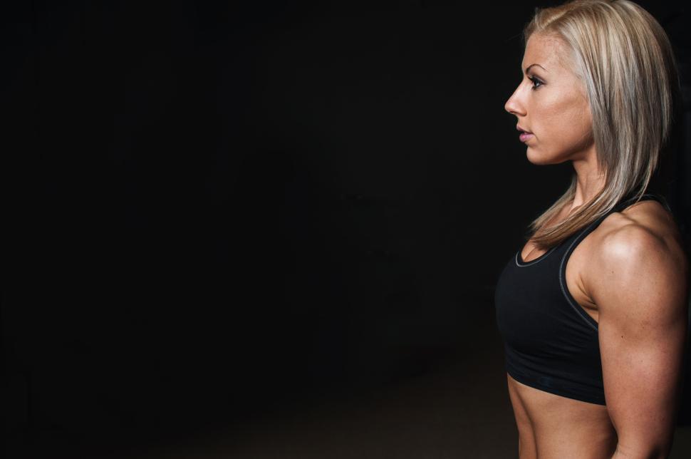 Free Image of Athletic woman in black sportswear flexing muscles 