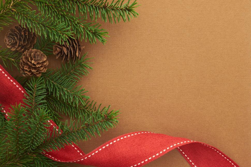 Free Image of Green pine branches with pine cones and red ribbon, festive 