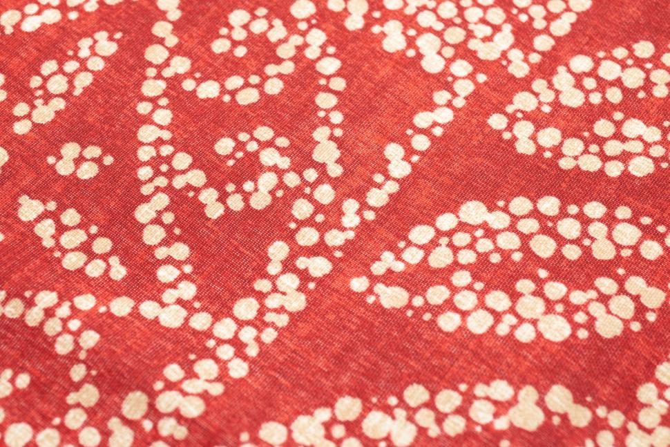 Free Image of Close-up of red fabric with white patterns and polka dots. 