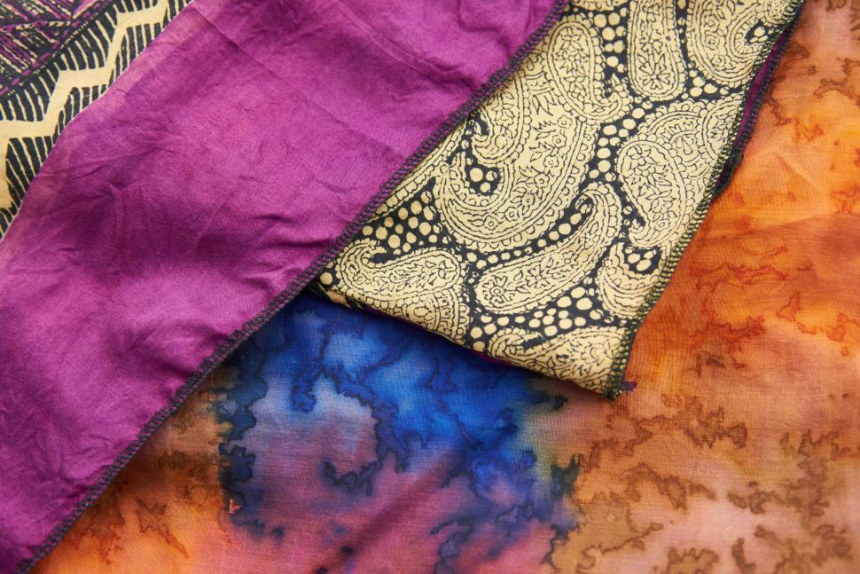 Free Image of Colorful fabric textiles layered with intricate designs. 