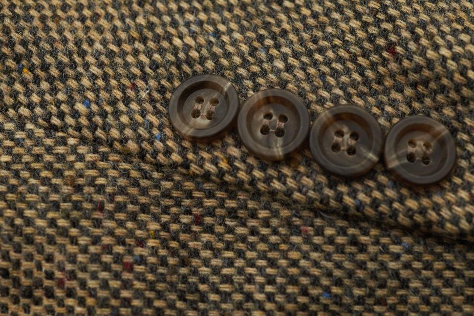 Free Image of Close-up of brown tweed fabric with dark buttons. 