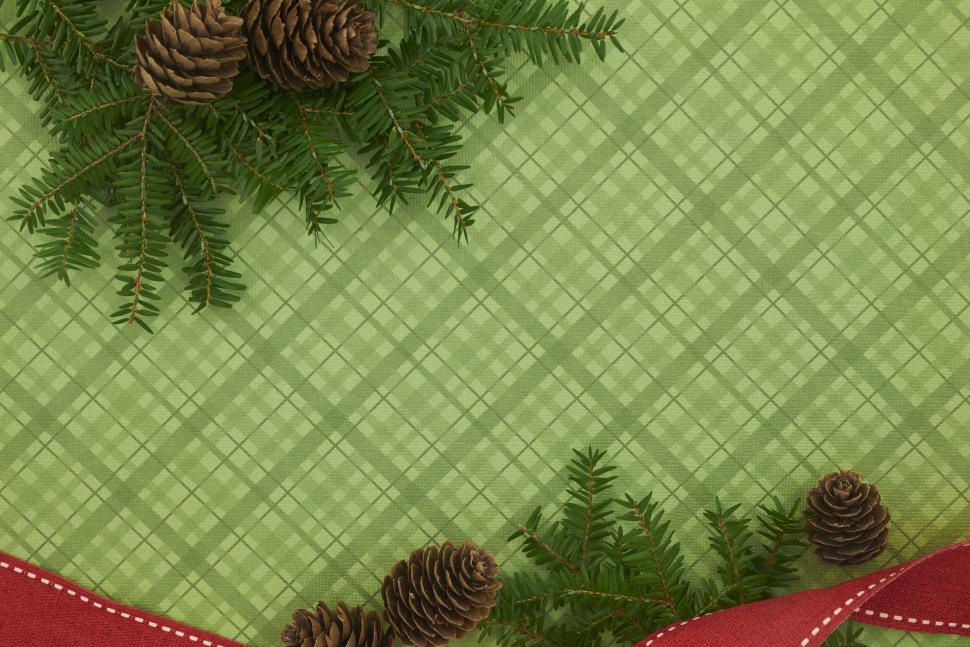 Free Image of Christmas-themed green plaid with red ribbon and pine. 