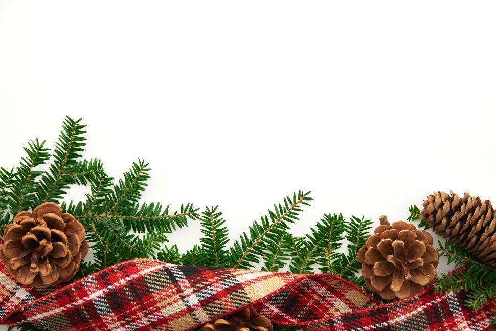 Free Image of Christmas arrangement with pine branches and plaid fabric. 