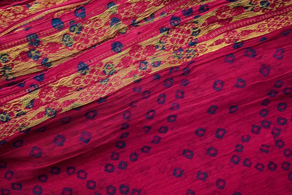 Free Image of Detailed red and gold fabric with intricate patterns 