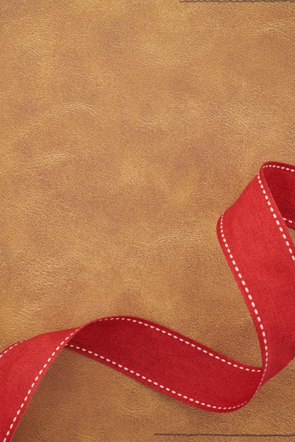 Free Image of Brown leather background with a red ribbon for decoration 